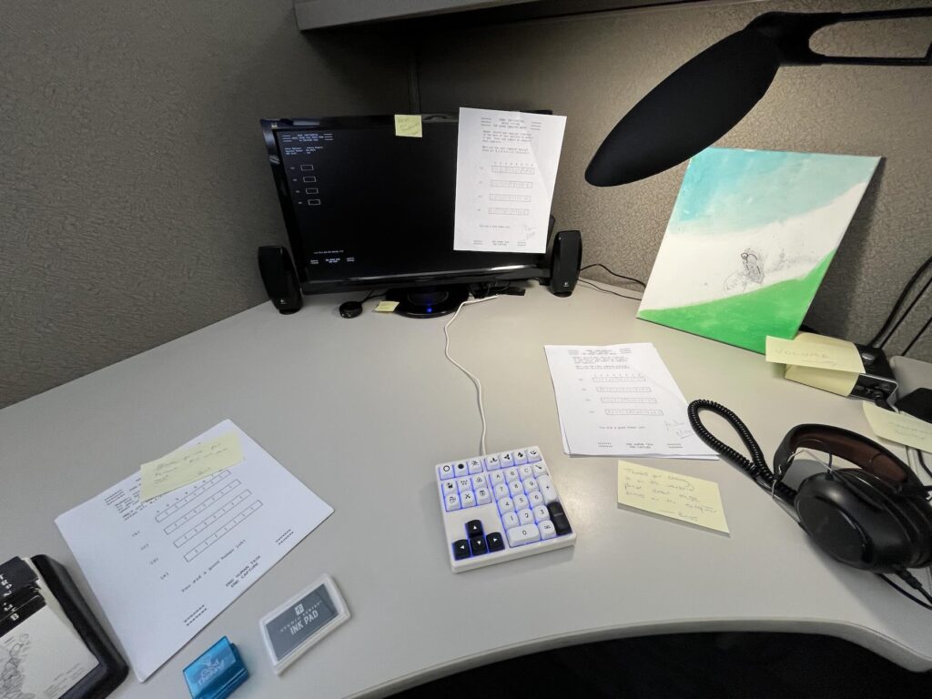 desk with keyboard monitor and miscellaneous items